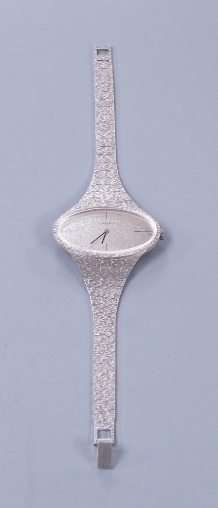 A lady's 1970's silver Longines manual wind wrist watch, with oval dial, on a textured silver bracelet.